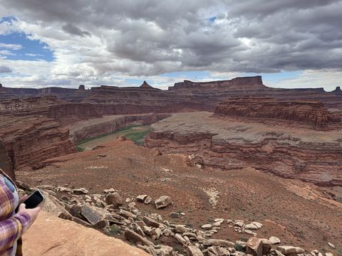 The Colorado River winding green through its inner gorge below the White Rim, buttes and mesas ranged along the skyline.