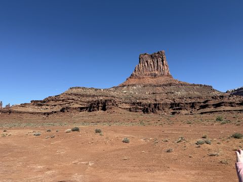 Airport Tower from the road, its banded pedestal spreading into a low bench of pale rock.