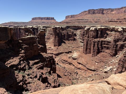 Monument Basin's spires seen along the rim, a mesa with a stepped profile closing the view behind.