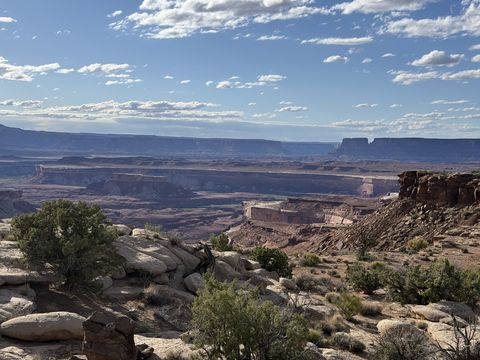 A hazy view over a deep canyon system, its benches and mesas fading into layers toward the horizon.